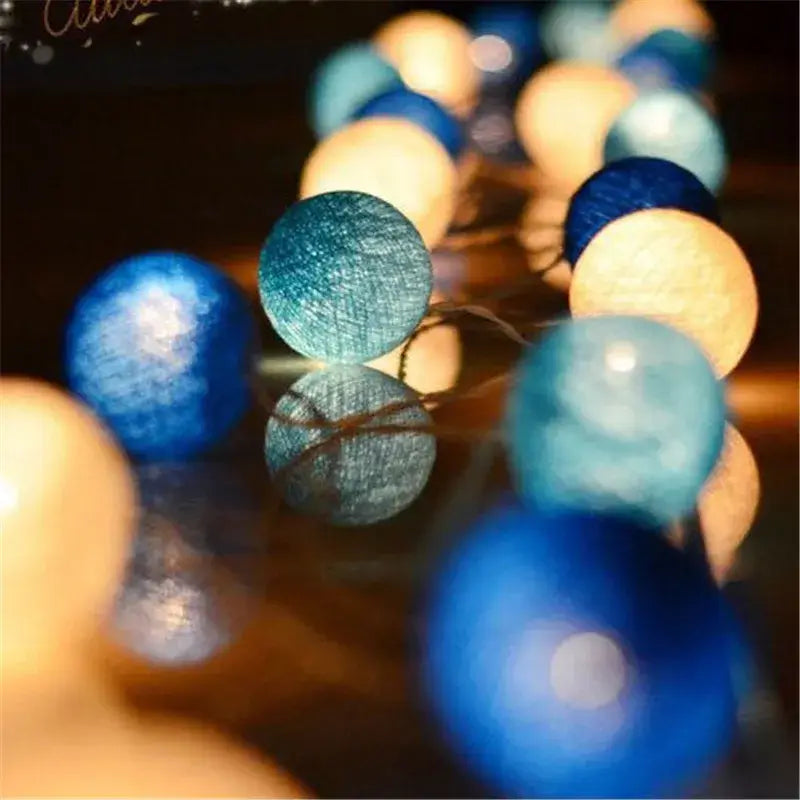 Blue and cream LED String Lights Cotton Balls glowing in the dark, great for festive or ambient room lighting.