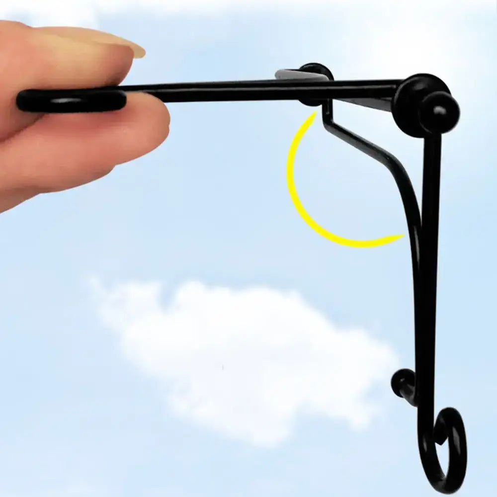 Hand holding black iron plate rack easel to show lightweight and foldable design. Great for displaying plaques, books, or plates.