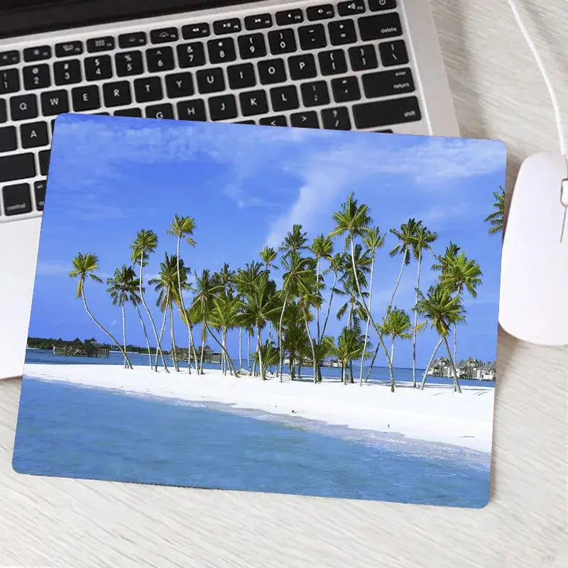 Gaming mouse pad with white sand beach and tall palm trees under clear blue sky. Custom design offers both visual appeal and precision.