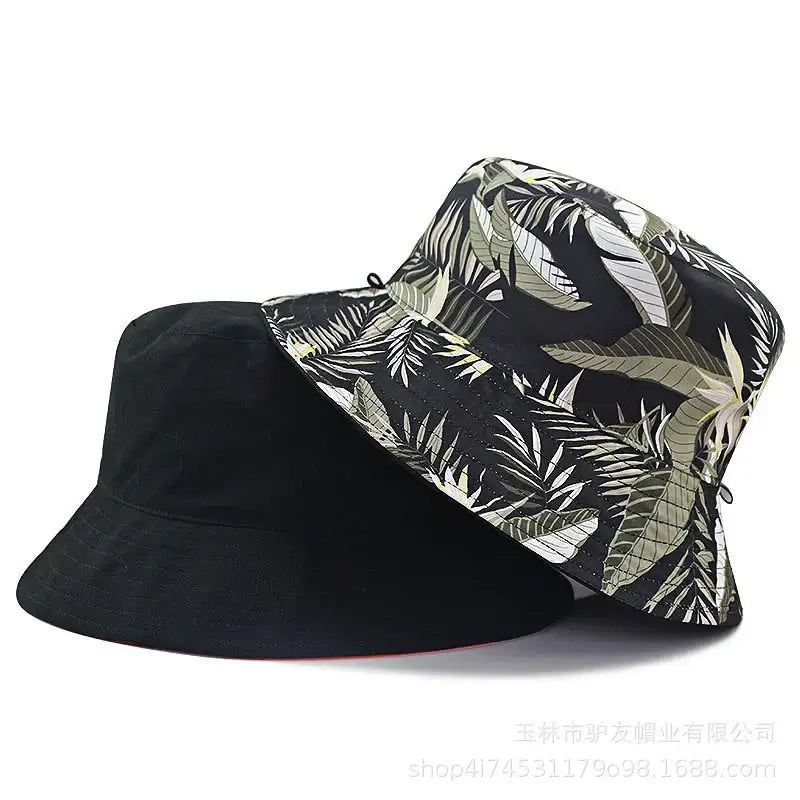Black and tropical leaf print oversize cotton bucket hats for unisex wear. Wide-brimmed for chic sun protection and summer versatility.