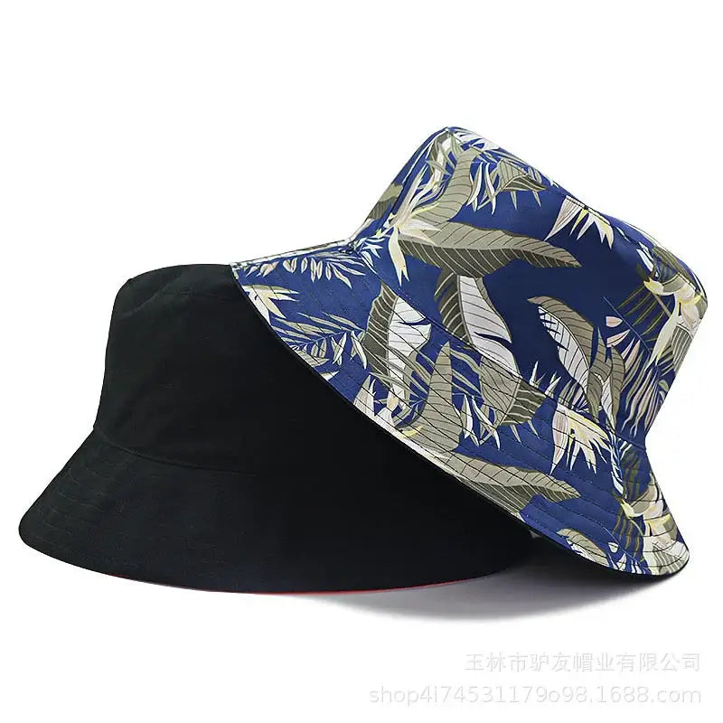 Oversize cotton bucket hats in black and navy tropical print. Unisex wide-brim style offers breathable comfort and chic sun protection.