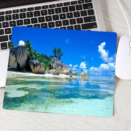 Gaming mouse pad with tropical beach and rock formation design for precision control. Custom style enhances desktop aesthetics and performance.