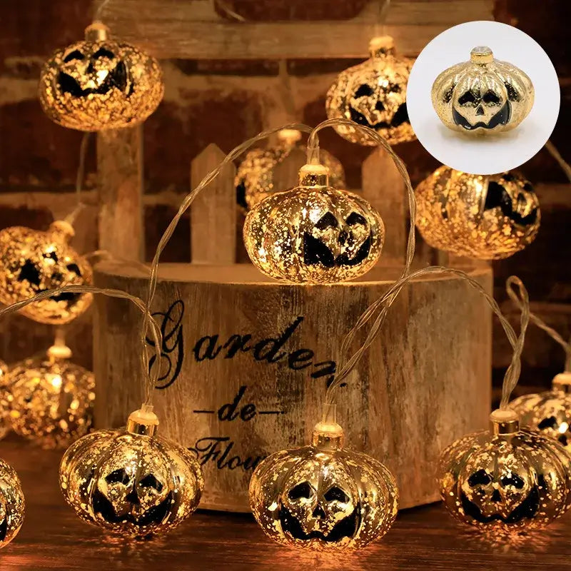 Gold glitter pumpkin LED string lights in a rustic wooden bucket. Elegant Halloween decor for home or garden.