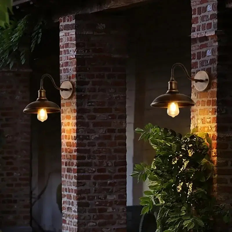 Pair of Retro Waterproof LED Wall Lamps illuminating a rustic brick villa exterior, enhancing outdoor ambiance with warm LED glow.