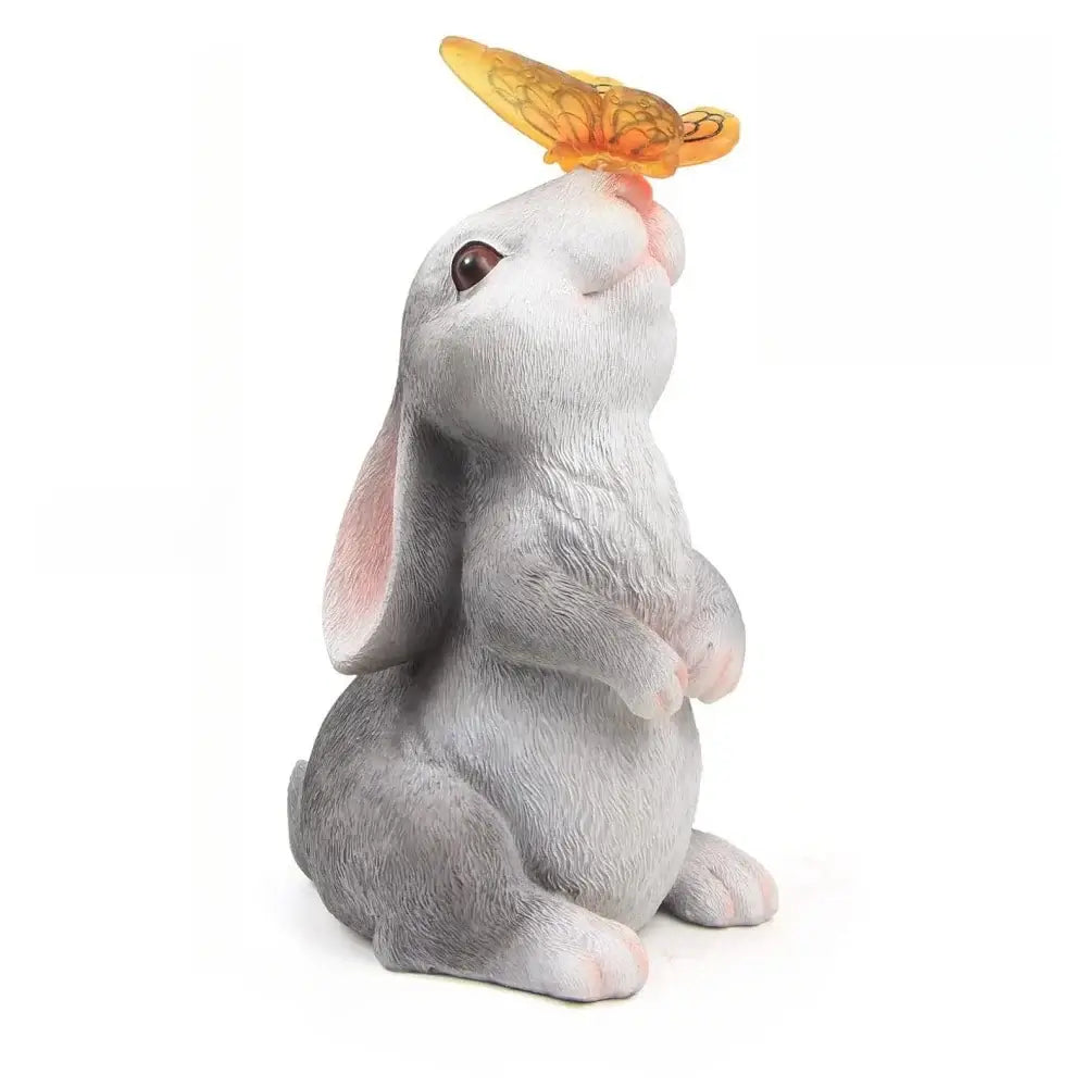 Side view of Solar Bunny Statue Decor with butterfly LED light. UV-resistant resin sculpture for patios, gardens, or walkways.