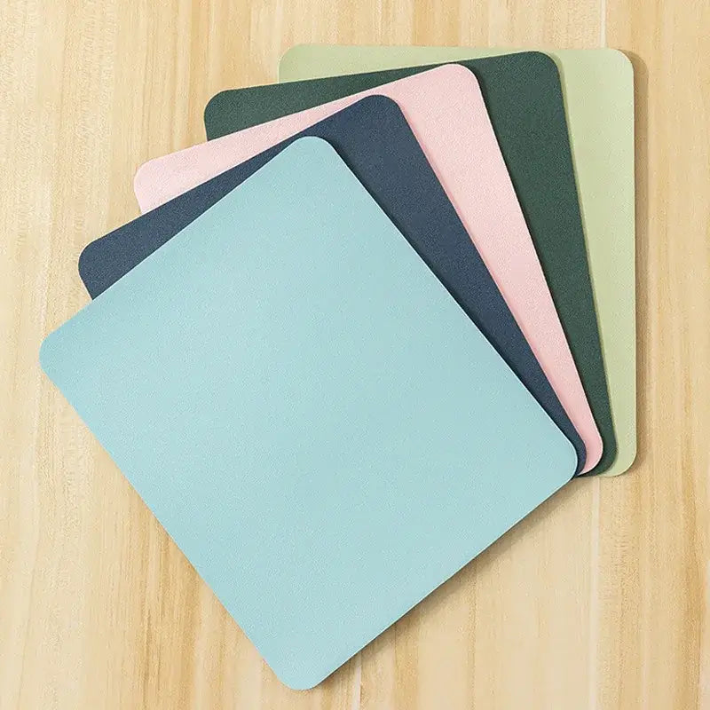 Stack of Small PU Leather Gaming Mouse Pads in soft colors, featuring a non-slip surface for precise mouse control.