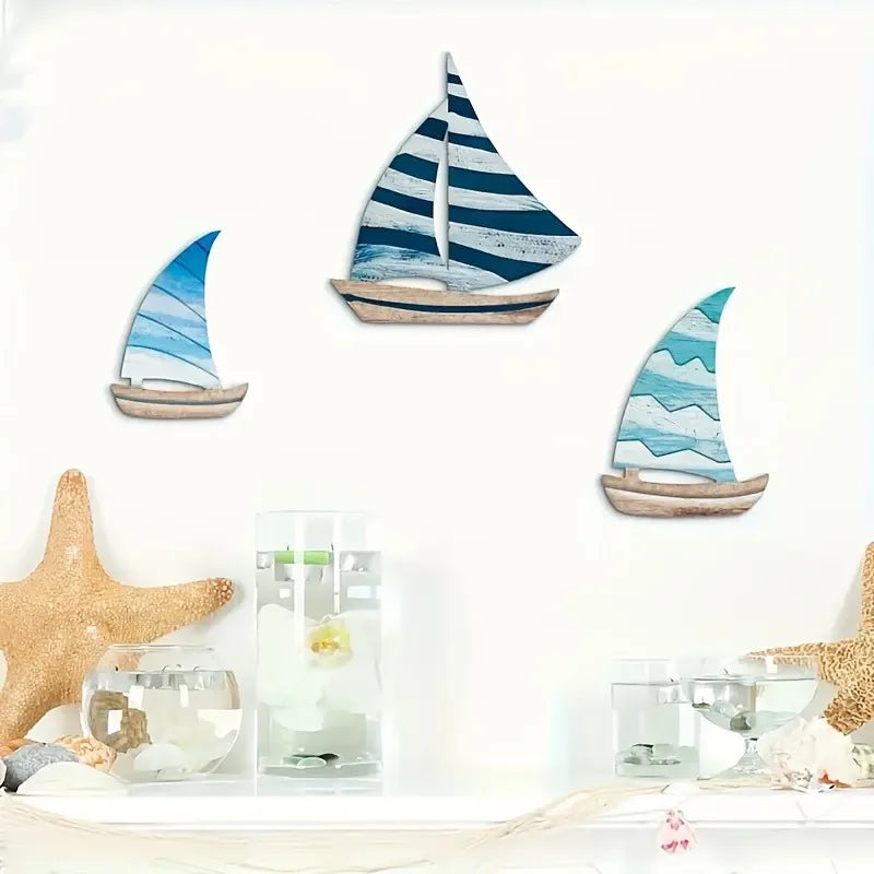 Wooden Sailboat Wall Art Set arranged above a white shelf with starfish and coastal decor. Adds maritime charm to any room.