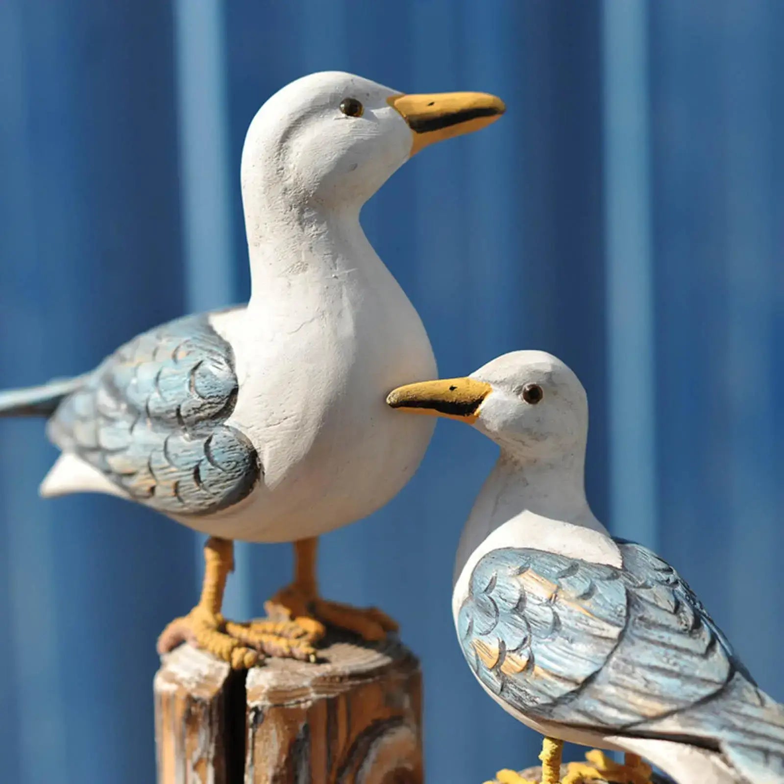 Close-up of 2pcs wooden seagull figurines with hand-painted blue wings and rope-wrapped bases, perfect for nautical-themed decor.