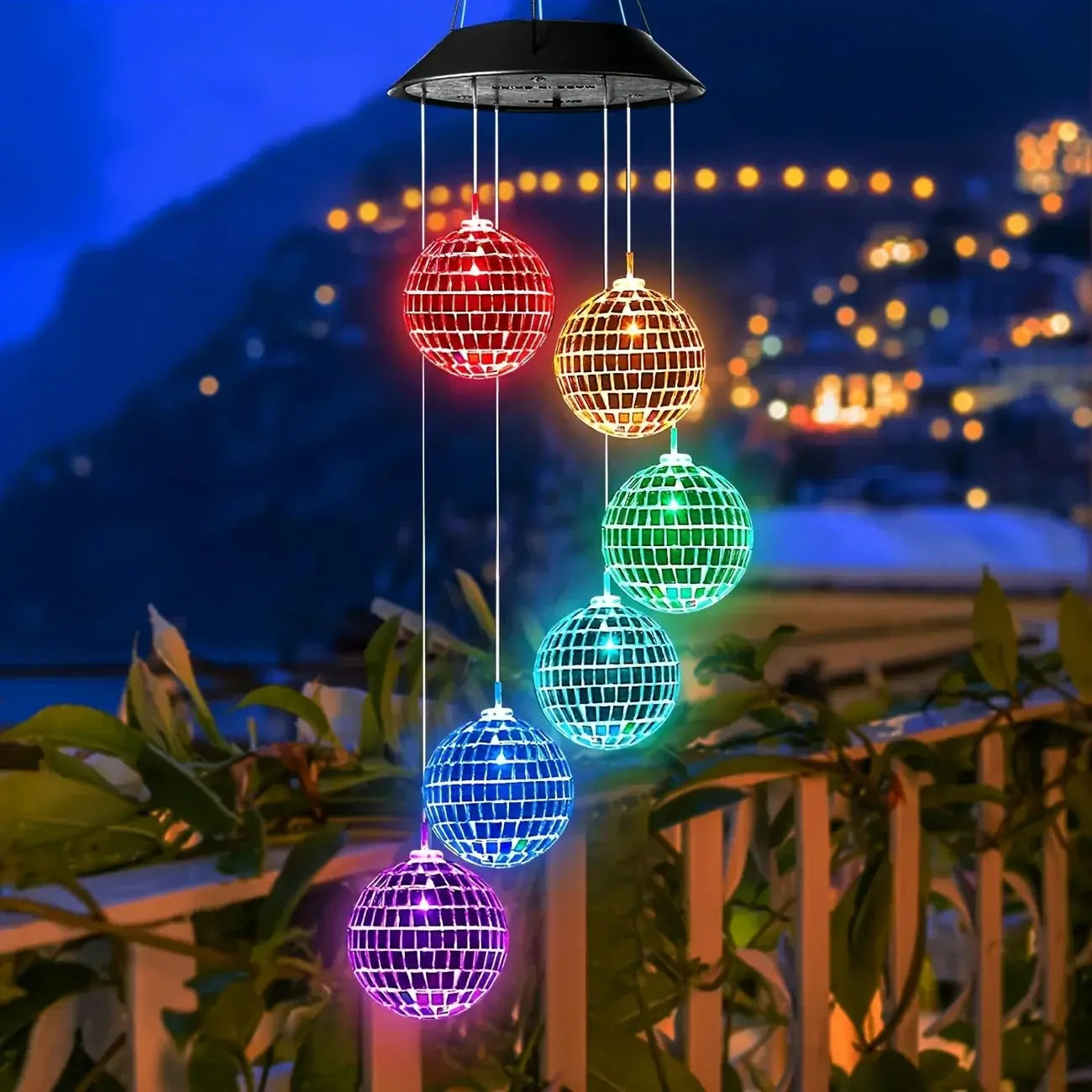 Morocco Ball Solar Wind Chime Light glowing in rainbow colors on a balcony at night, enhancing outdoor decor with LED charm.