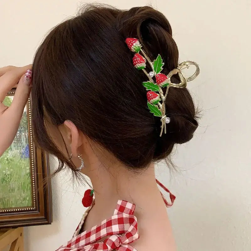 Strawberry-themed ponytail hair clip with red berries and green leaves, ideal for a playful and secure hairstyle.