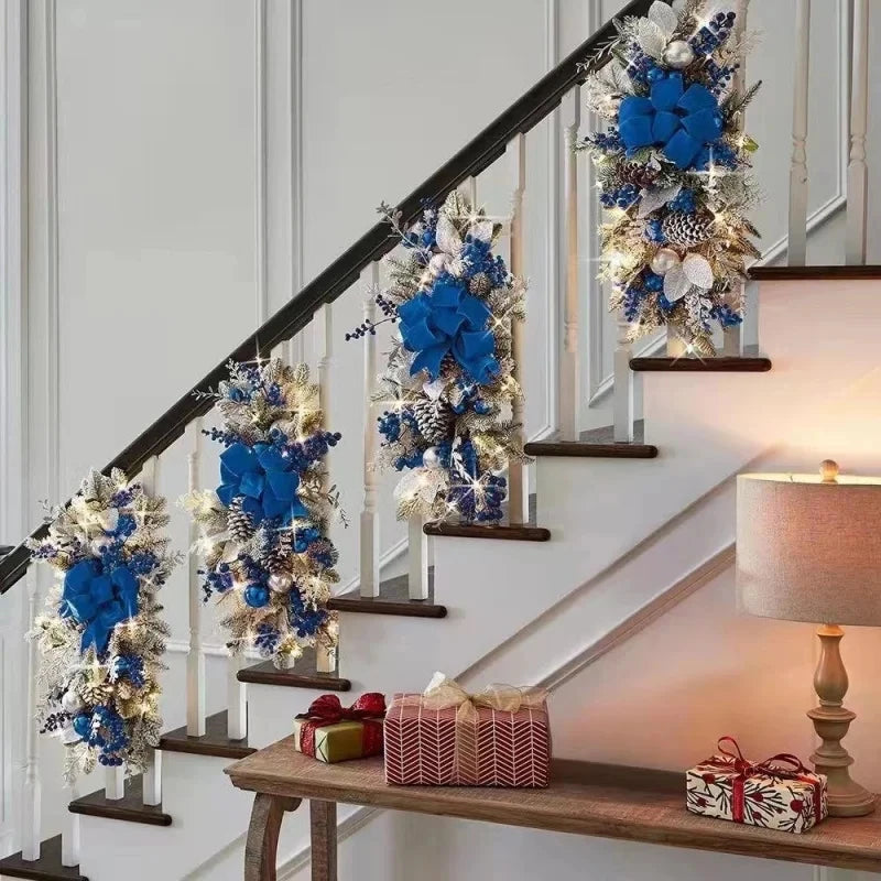 Blue Christmas Stair Wreaths with lights and snowy pine accents on staircase. Elegant holiday decor for stair railings and home interiors.