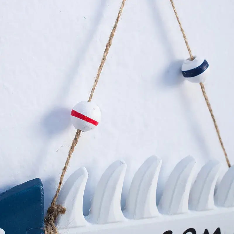 Close-up of nautical rope and red and blue beads on the Mediterranean Beach Welcome Sign, enhancing its coastal charm.