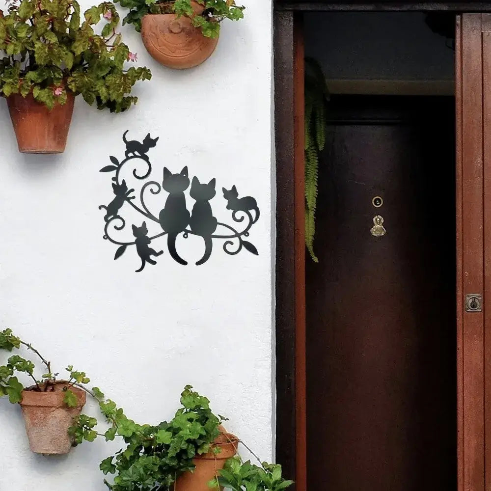 Metal Black Cat Silhouette wall art decorates a white exterior wall near a door, ideal for garden or porch decoration in home decor themes.
