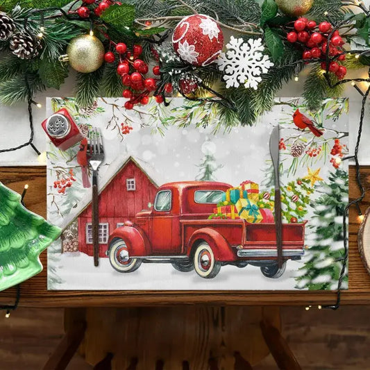 Linen Christmas placemat featuring red vintage truck with gifts and barn, ideal for festive table decor. Water absorbent and wrinkle-resistant.