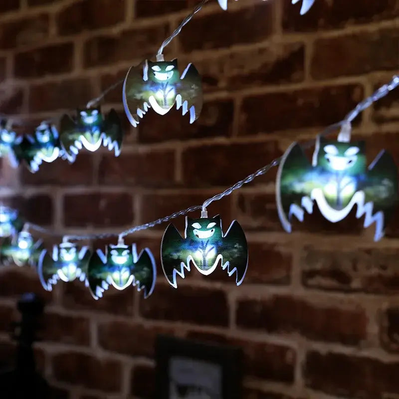 Halloween LED bat string lights glowing against a brick wall. Perfect for haunted house or party decorations.