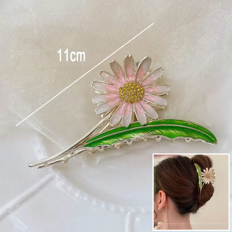 Pink daisy ponytail hair clip with green leaf, 11cm long, designed for secure hold and floral elegance in updos.