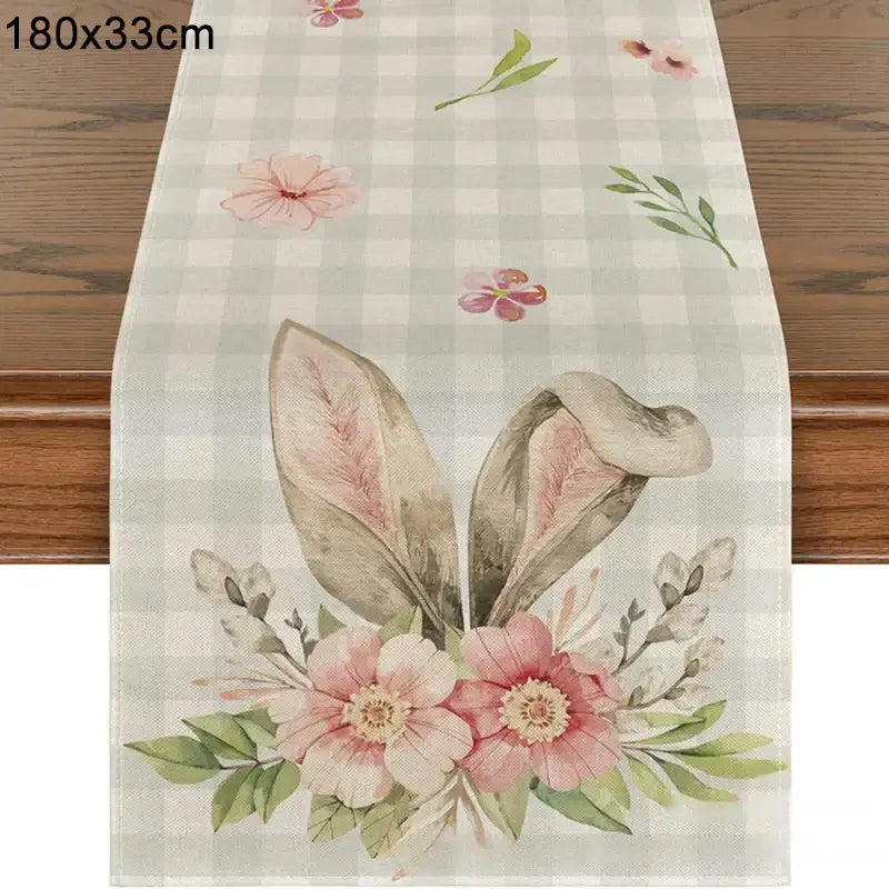 Linen Easter Bunny Table Runner with floral bunny ears on a pastel checkered background. Measures 180x33cm, perfect for spring decor.