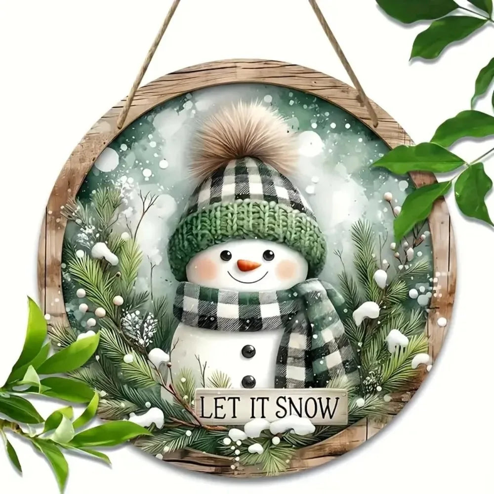 Charming Snowman Circular Wooden Sign surrounded by greenery, featuring a cute snowman with 'Let It Snow' message, ideal for winter home decor.