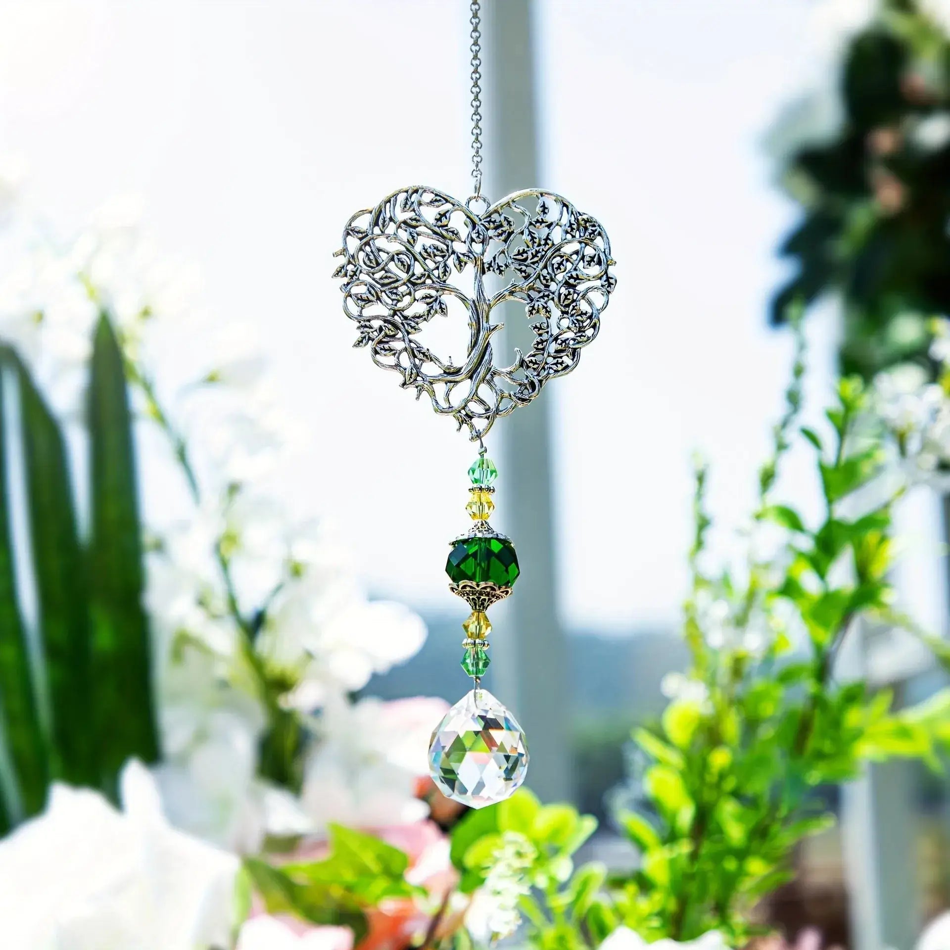 Tree of Life Suncatcher - Crystal Pendant hanging in a sunlit garden with floral background, ideal for window or outdoor decor.