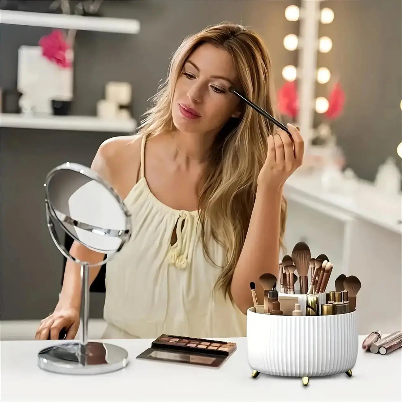 Woman using makeup at vanity with 360 rotating storage box - 5 compartments organizer holding brushes and cosmetics on the table.