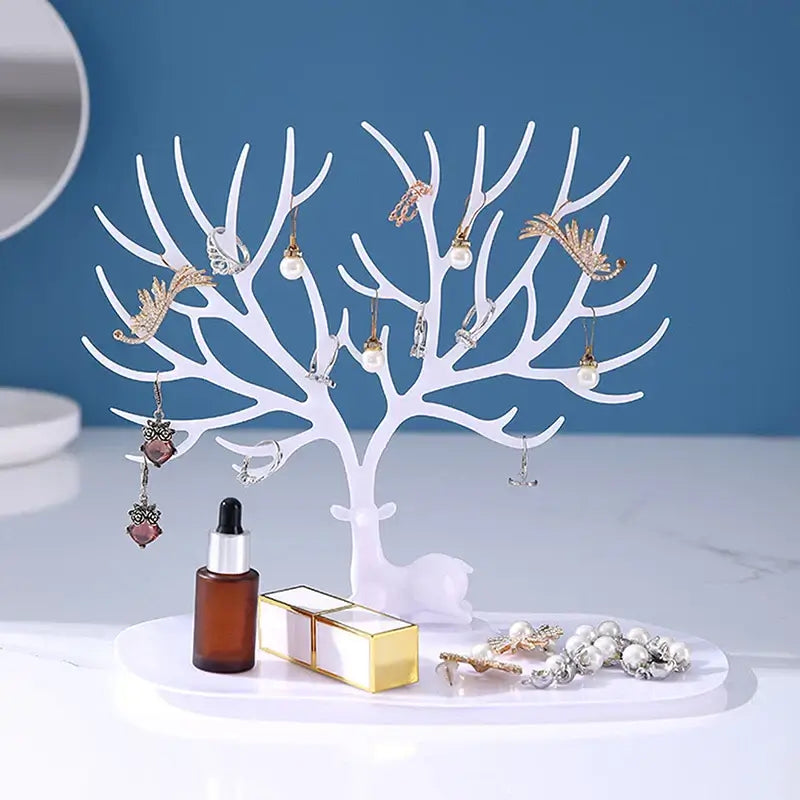 White Jewelry Tree Storage Rack with deer base holding earrings and rings. Stylish stand for organizing beauty accessories.