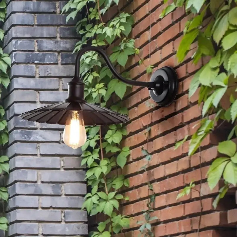 Vintage-style waterproof LED wall lamp with flared shade on a brick wall, perfect for outdoor garden or courtyard lighting.