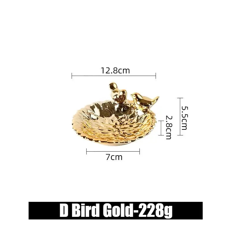 Gold ceramic flower-shaped jewelry tray with bird figurines, labeled D Bird Gold, ideal for luxury accessory display.