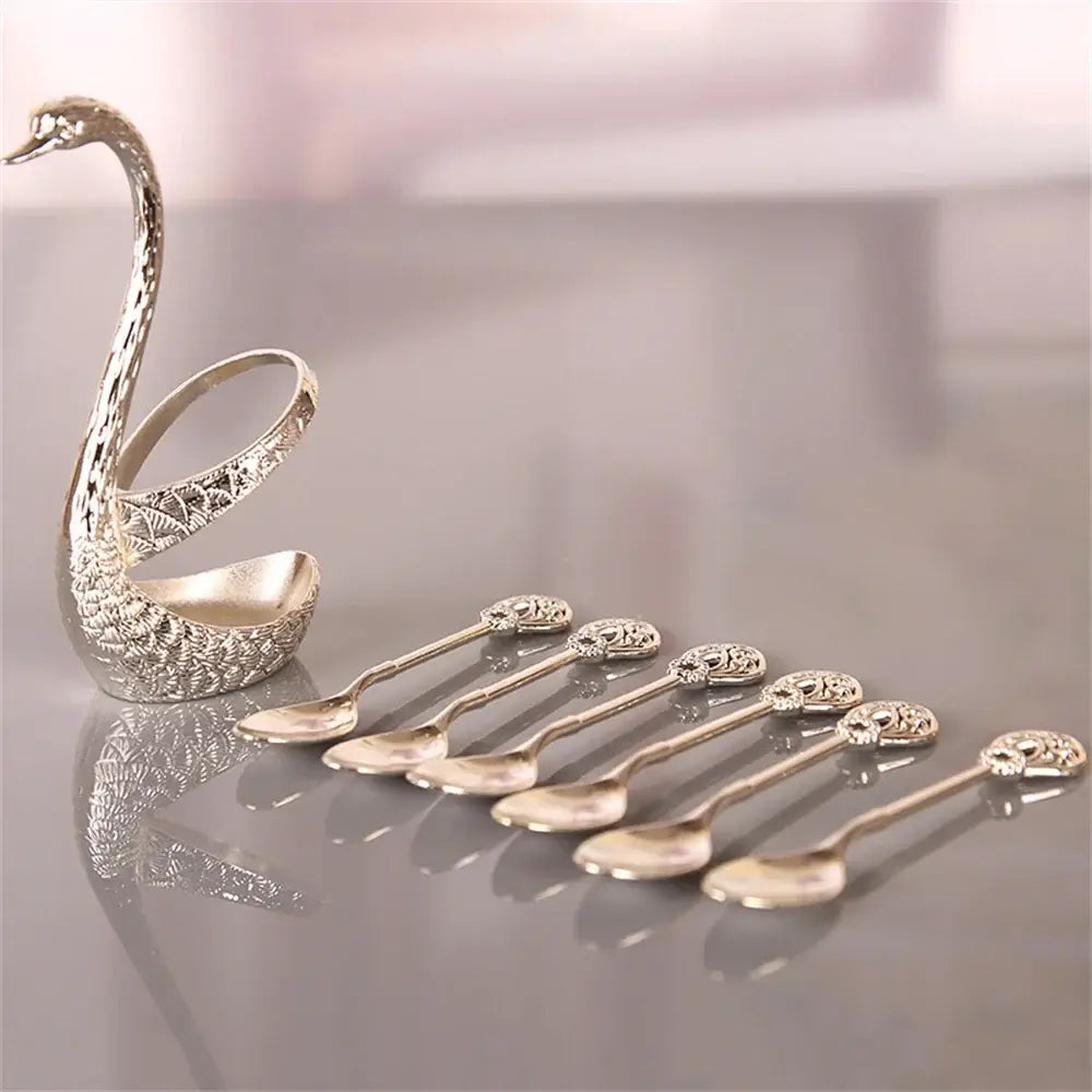 Silver Swan Base Holder with 6 matching spoons laid out, showcasing detailed craftsmanship for luxury tableware.