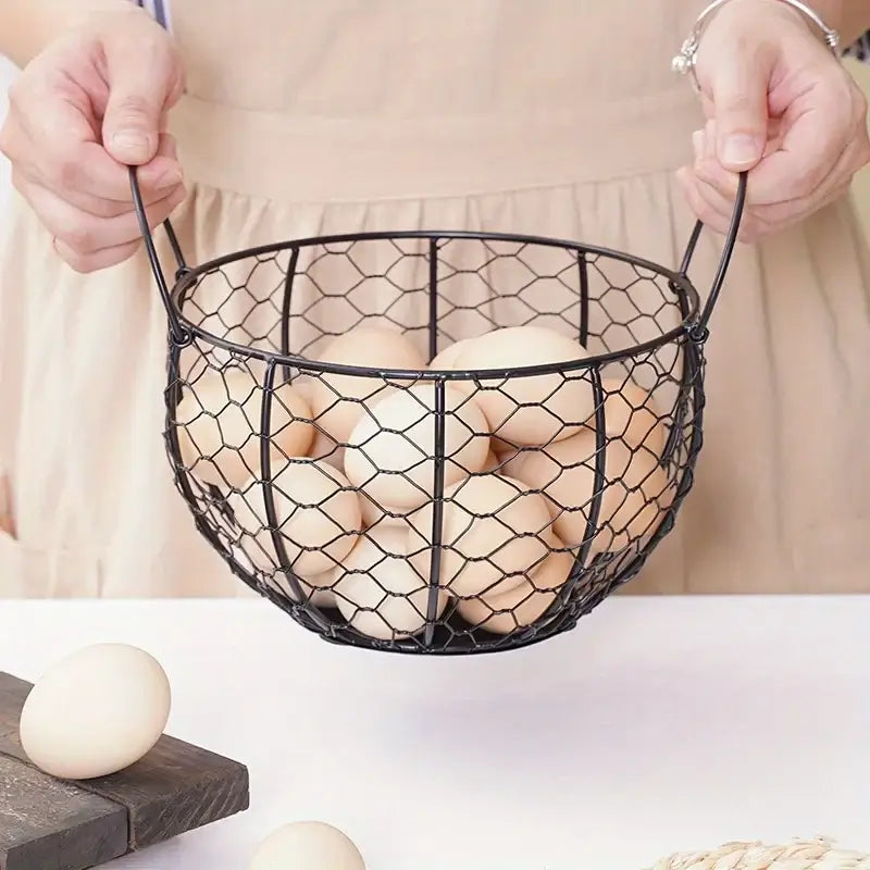 Person holding metal wire egg basket filled with eggs. Durable iron handles for easy transport and kitchen use.
