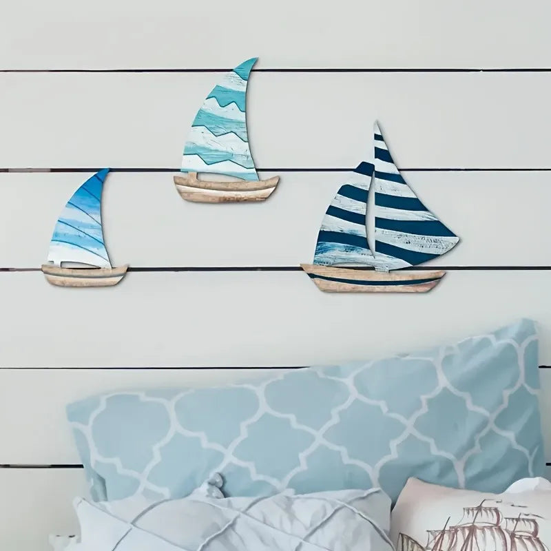 Wooden Sailboat Wall Art Set above a bed with blue and white bedding. Brings a classic nautical touch to bedroom interiors.