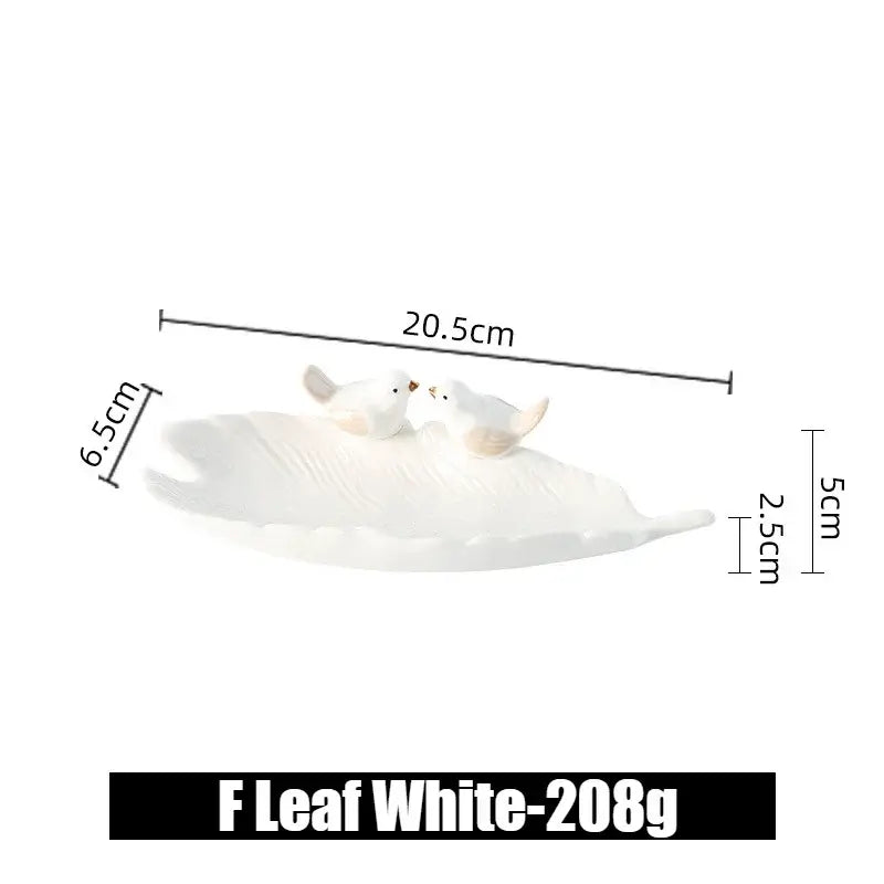 White ceramic leaf jewelry tray with bird figurines, labeled F Leaf White, showing its elegant curved profile and dimensions.
