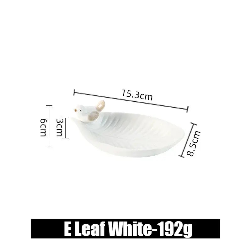 White ceramic leaf jewelry tray with a single bird figurine, labeled E Leaf White, compact and stylish for small items.