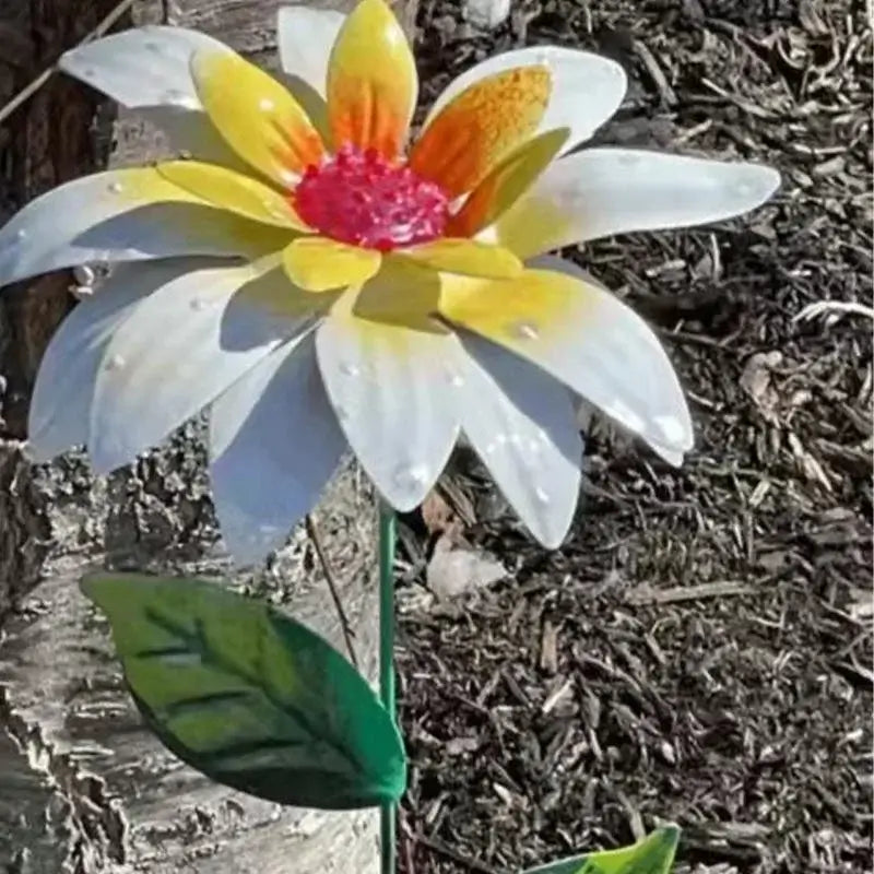 Close-up of a white and yellow Metal Flower Garden Stake with green leaves, perfect for garden sculptures and lawn ornaments.