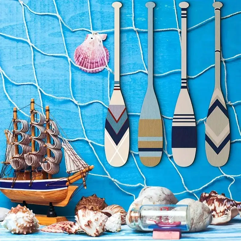 Handcrafted nautical paddles decor displayed on a blue fishing net wall with seashells and a model ship, evoking seaside vibes.