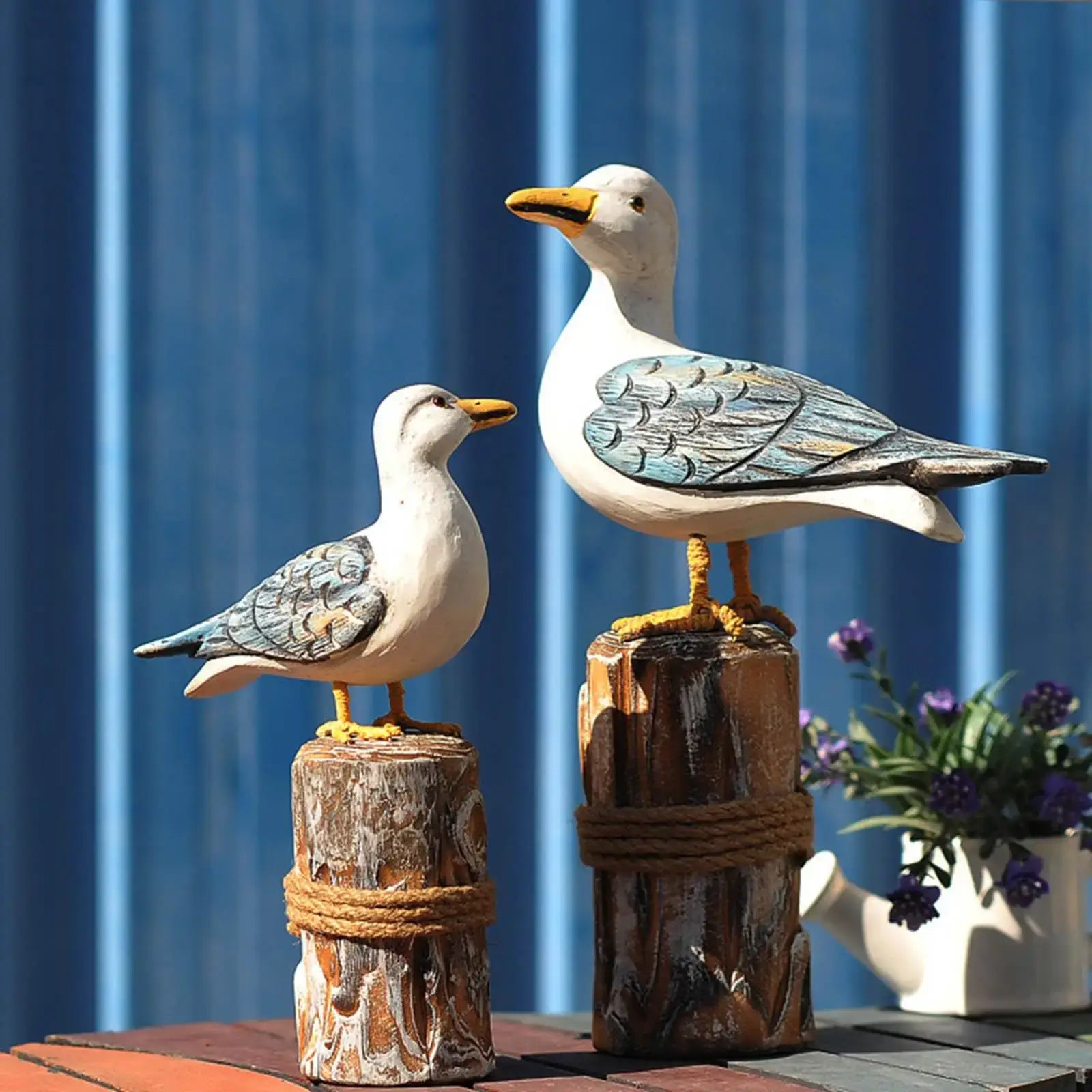 Rustic nautical decor featuring 2pcs wooden seagull figurine set with blue accents, perfect for coastal-themed garden sculptures.