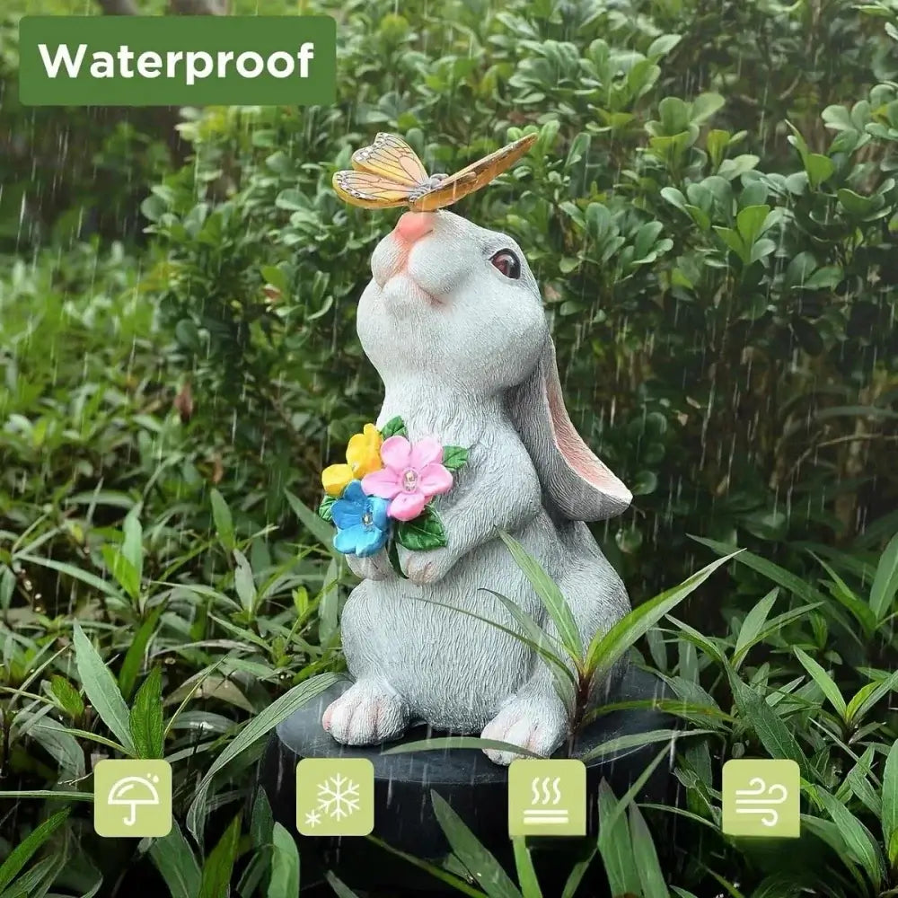Waterproof Solar Bunny Statue with LED butterfly and flower lights. Durable garden sculpture for all-weather outdoor decor.