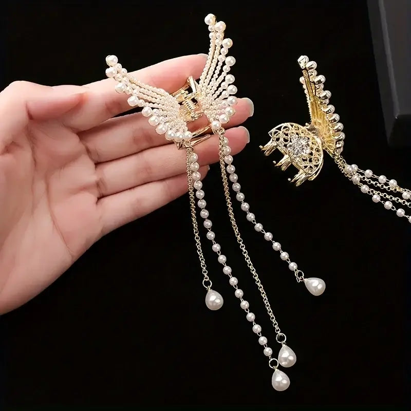 Hand holding Women Butterfly Tassel Hair Clip with pearl strands. Gold butterfly clip with long tassels ideal for accessorizing any hairstyle.