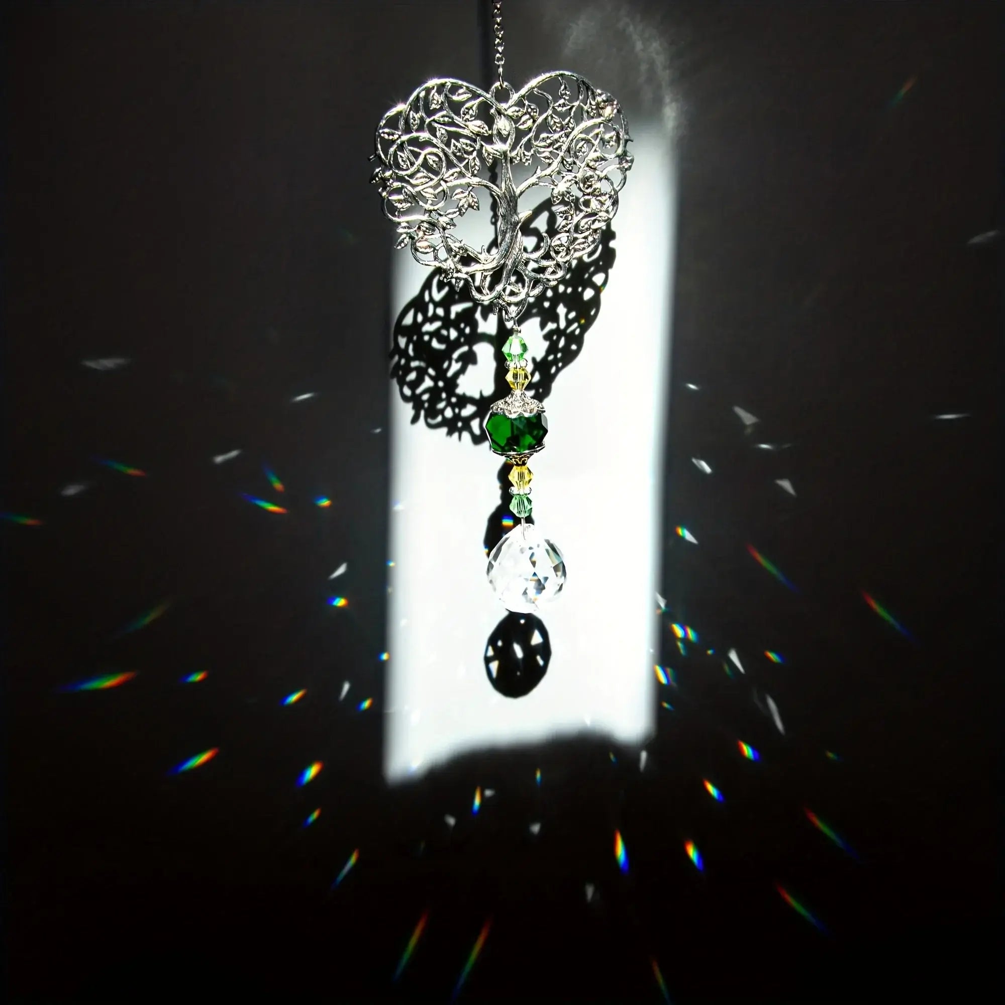 Tree of Life Suncatcher - Crystal Pendant casting rainbow reflections in dark light, creating a magical indoor lighting effect.