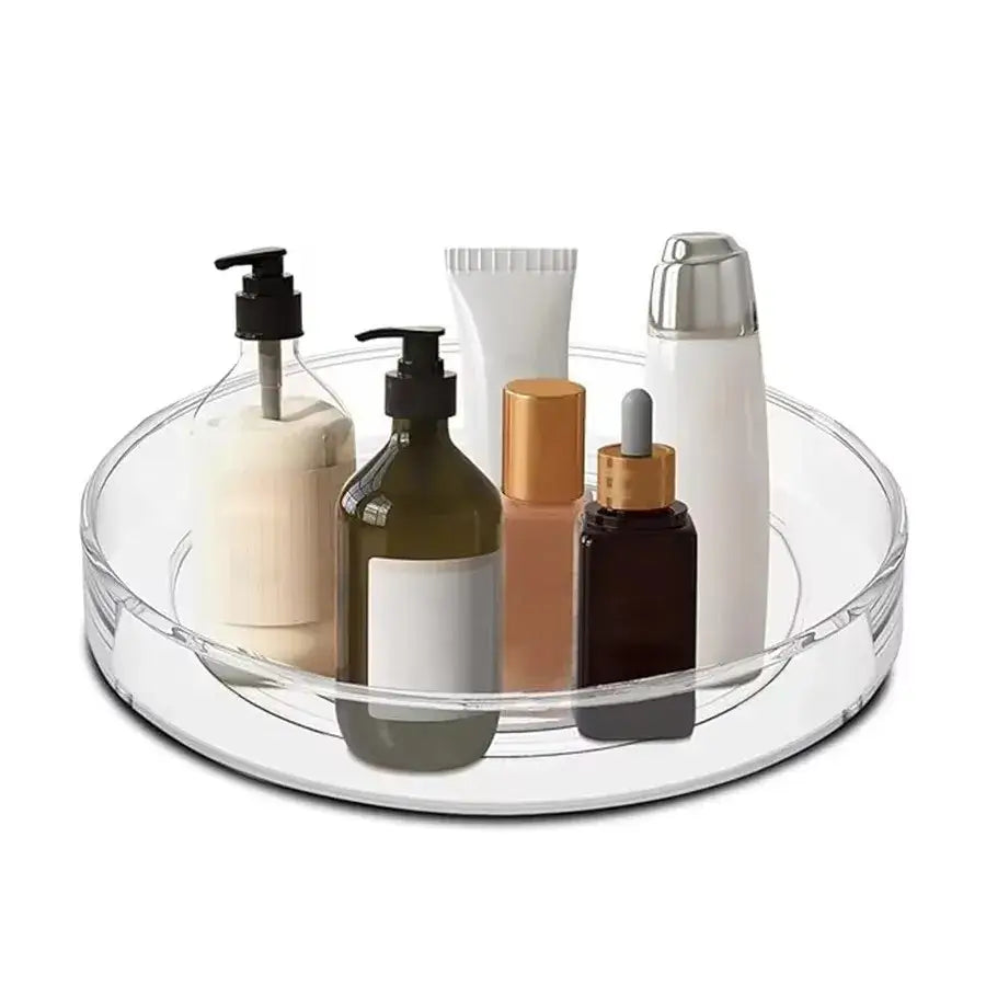 360 Rotating Cabinet Organizer holding skincare and cosmetic bottles. Clear, non-slip tray ideal for vanity or bathroom countertop organization.
