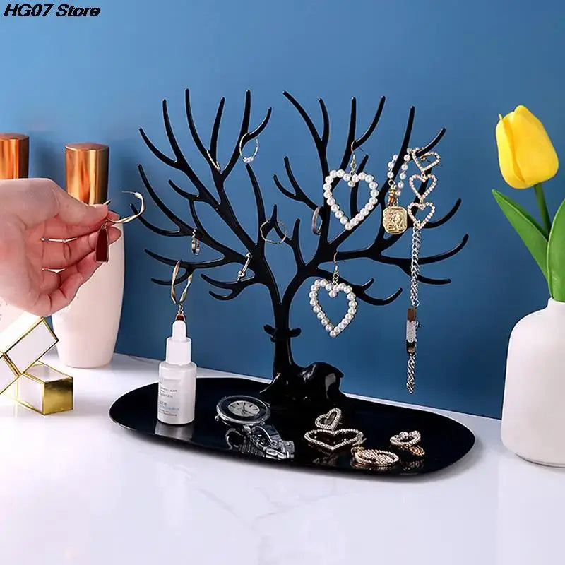 User placing earrings on black Jewelry Tree Storage Rack. Multi-branch organizer for bracelets, rings, and accessories.