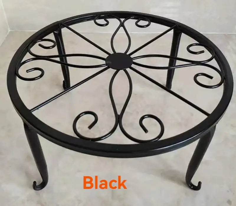 Black metal plant stand with curved legs and scroll detailing, designed for heavy pots and eco-conscious garden decor.