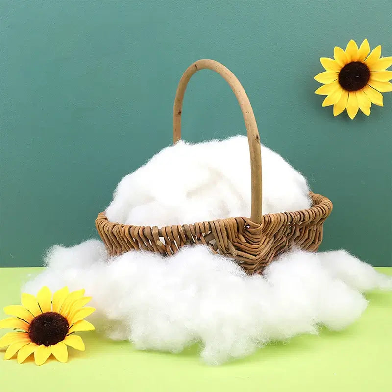 Basket filled with KRABALL Polyester Fiberfill surrounded by fluffy stuffing and sunflowers. Great for DIY crafts and plush toys.
