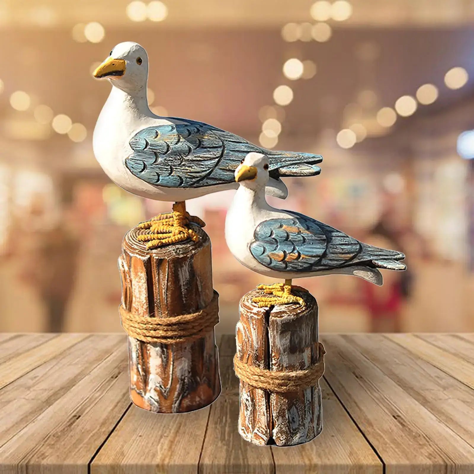 Decorative 2pcs wooden seagull figurine set displayed indoors, showcasing nautical charm for home or garden sculpture collections.