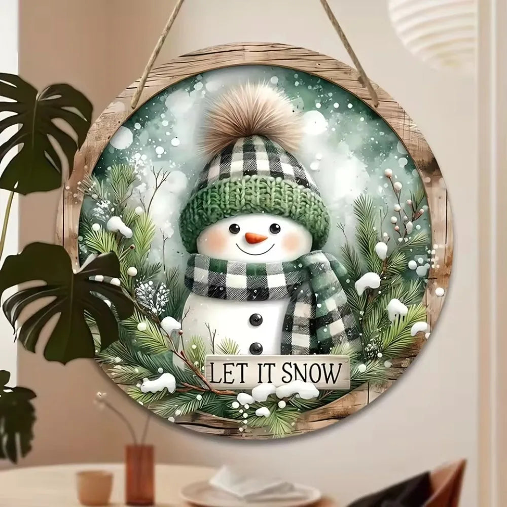Snowman Sign - Wooden Circular Art | 20x20cm Design hanging near indoor plants, blending festive charm with natural home decor elements.