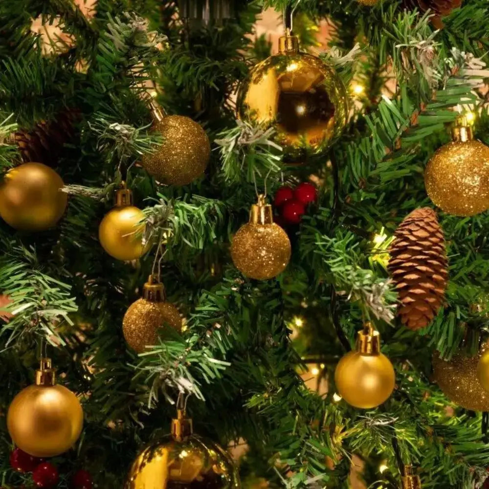 Gold plastic Christmas balls from the 100PCS set displayed on a decorated tree, adding festive sparkle to seasonal home decor.