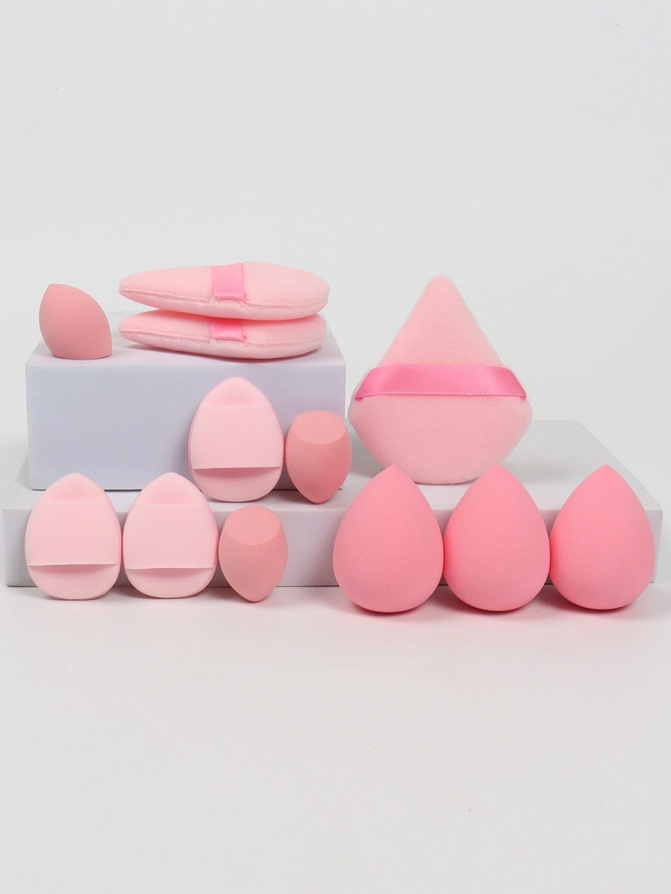 Baby pink 12-piece makeup sponge set with soft puffs and blending sponges. Offers smooth, even coverage for all makeup types.